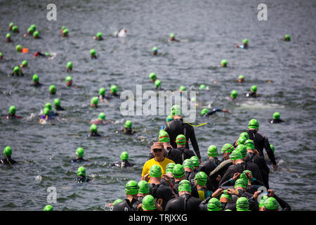 Les triathlètes sauter dans un lac sur le 1er niveau natation section triathlon à un événement tenu à Blenheim Palace, Oxfordshire, UK Banque D'Images