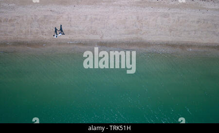 Promenades Couple on beach, ombres holding hand, de haut en bas vue aérienne Banque D'Images