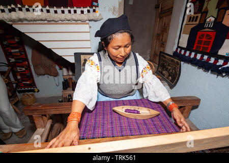 Une femme tissant avec la fusée et à tisser dans un village de Peguche, tisserands près d'Otavalo, Equateur, Amérique du Sud. Banque D'Images