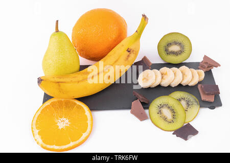 Vue de dessus de tranches de kiwis et oranges, ensemble de la banane, chocolat sur un arrière-plan lumineux Banque D'Images