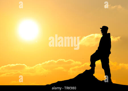 Silhouette de soldat au fusil contre un coucher de soleil Banque D'Images