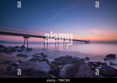 Pont sur la plage au coucher du soleil Banque D'Images