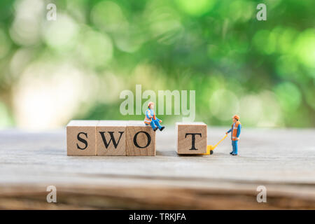 Les gens miniature travailleur de la Construction avec l'équipe de word en bois en arrière-plan et l'entreprise concept swot avec copie espace. Banque D'Images