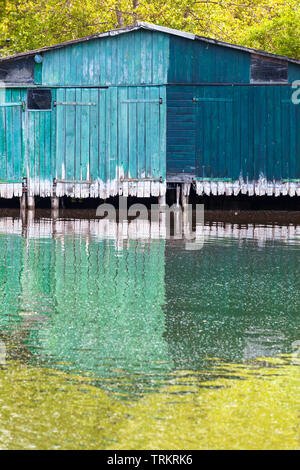 Bateau en bois vert minable chambre shed se reflète dans l'eau (copie espace) Banque D'Images