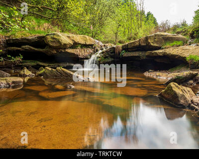 Petite cascade rocheuse sur un ruisseau dans le North Yorkshire avec réflexions douces sur la piscine d'eau à la dérive Banque D'Images