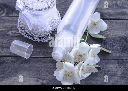 Jasmine esthétique de l'eau dans une bouteille sur un fond sombre. Procédures cosmétiques Banque D'Images