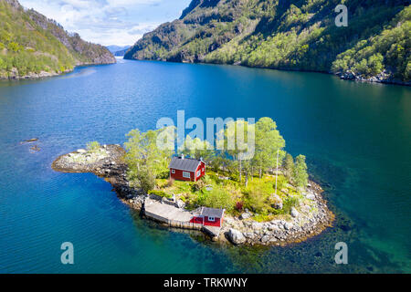 Rouge typique chalet norvégien sur une petite île dans le fjord, tourné à partir d'un drone, Lovrafjord, Norvège Banque D'Images