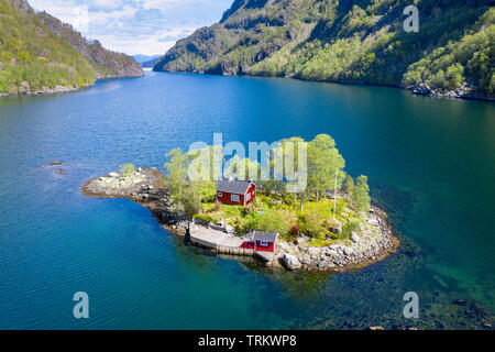 Rouge typique chalet norvégien sur une petite île dans le fjord, tourné à partir d'un drone, Lovrafjord, Norvège Banque D'Images