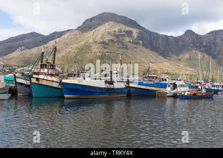 Hout Bay Harbour et colorés bateaux ou navires de pêche commerciale sur un fond de montagnes à Cape Town, Afrique du Sud Banque D'Images