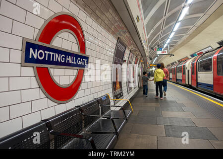 Une mère et son fils descendre la plate-forme à Notting Hill Gate platform étant arrivé dans un train. Banque D'Images