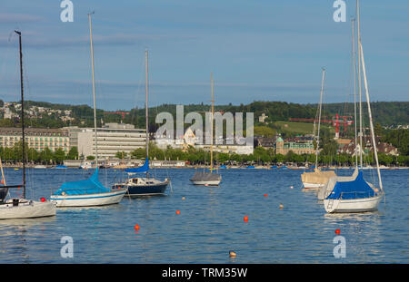 Bateaux sur le lac de Zurich en Suisse au coucher du soleil en été, les bâtiments de la ville de Zurich à l'arrière-plan. Banque D'Images