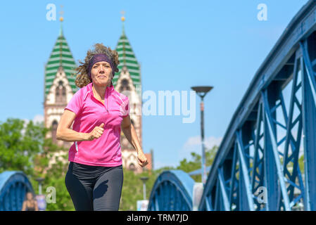 Portrait d'une femme à travers un jogging urbain bridge cintrées Banque D'Images