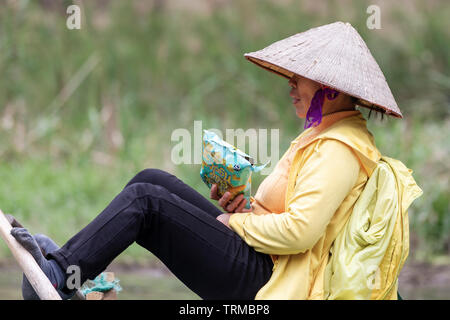 NINH BINH, VIETNAM - février 2019 ; Vietnamese Woman Rowing avec pied Banque D'Images