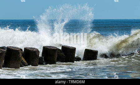 Vagues et éclaboussures sur une jetée au large de la côte de Long Island, New York. Banque D'Images