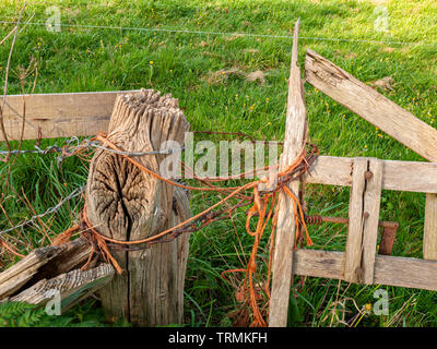 Détail de l'ancienne barrière en bois médaillon avec ficelle orange et la chaîne Banque D'Images