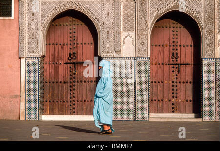 Femme arabe voilée en face de bâtiment historique, Marrakech, Maroc Banque D'Images