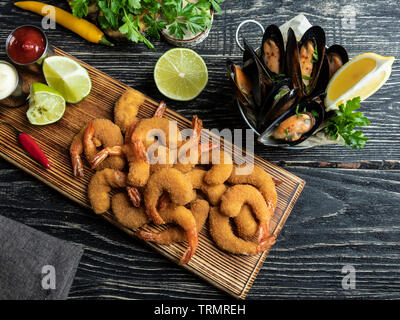 Les moules, crevettes pané frit servi avec de la chaux sur planche de bois, de délicieux, profonde rouge, la sauce blanche Banque D'Images