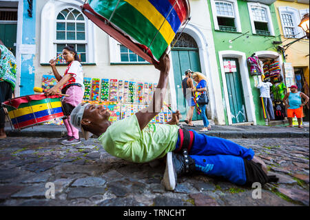 SALVADOR, BRÉSIL - Mars, 2018 : un batteur énergique se produit devant architecture colorée de Pelourinho, dans le cadre d'un projet social. Banque D'Images