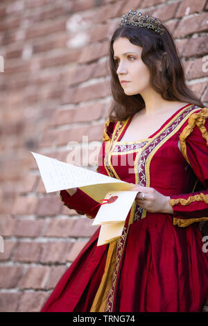 Femme en robe renaissance lisant une lettre Banque D'Images