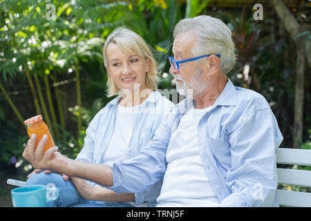 Vieil homme et lunettes pour lire les petites étiquettes sur les pots de confiture.concept de vision-image. Banque D'Images