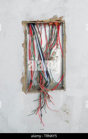 Les fils électriques d'un cadre d'énergie d'une maison en construction. Fils exposés, de l'énergie fort sur le mur. Banque D'Images