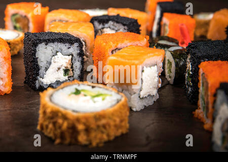 Un grand nombre de rouleaux dans le style japonais sur une surface sombre, vue latérale avec selective focus Banque D'Images