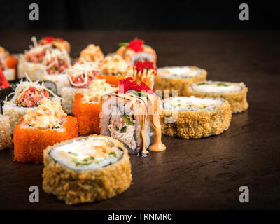 Un grand nombre de rouleaux dans le style japonais sur une surface sombre, vue latérale avec selective focus Banque D'Images