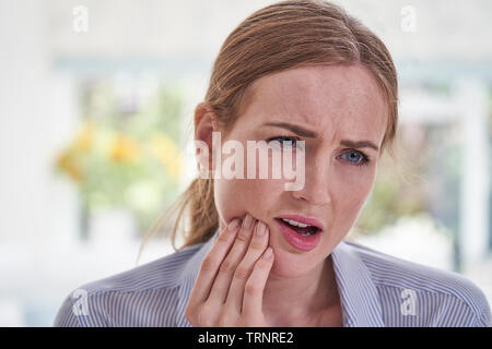 Jeune femme souffrant de maux touchant Jaw Banque D'Images