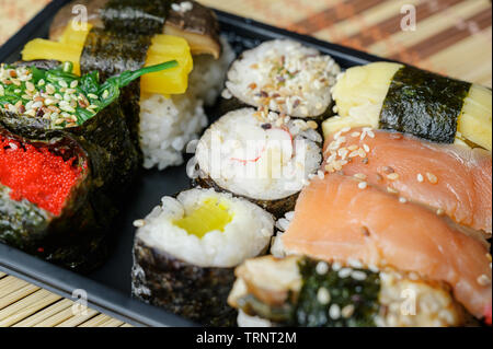 Ensemble de divers pains en boîte en plastique noir. Rolles collection avec des bâtons de crabe, saumon, le saumon coho, saumon, caviar, masago, shiitake wakame mu Banque D'Images