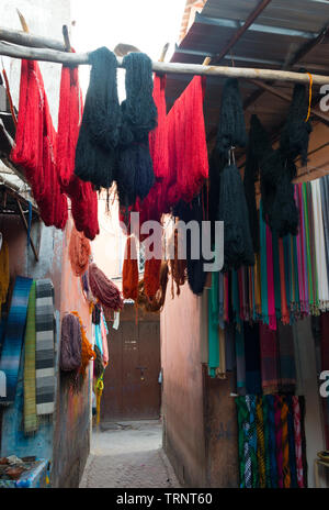 Bottes de laine teints accroché à sécher dans le souk des teinturiers Marrakech, Maroc Banque D'Images