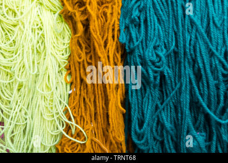 Bottes de laine teints accroché à sécher dans le souk des teinturiers Marrakech, Maroc Banque D'Images