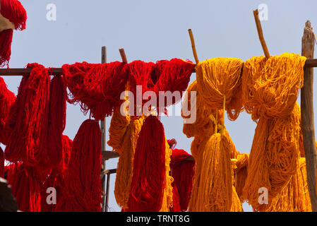Bottes de laine teints accroché à sécher dans le souk des teinturiers Marrakech, Maroc Banque D'Images
