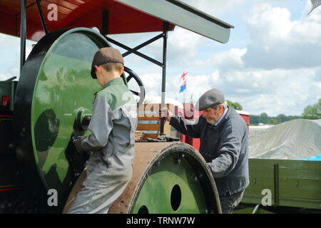 Un jeune et un homme plus âgé travaillant sur un moteur de traction au rallye 2019 Woodcote Banque D'Images