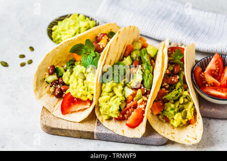 Vegan tortillas avec le quinoa, les asperges, les haricots, les légumes et le guacamole. Banque D'Images