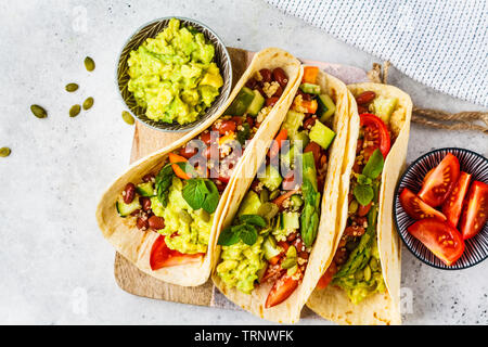 Vegan tortillas avec le quinoa, les asperges, les haricots, les légumes et le guacamole. Banque D'Images