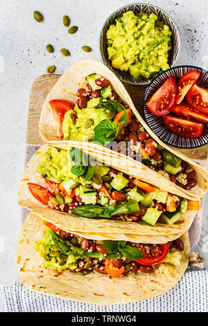 Vegan tortillas avec le quinoa, les asperges, les haricots, les légumes et le guacamole. Banque D'Images