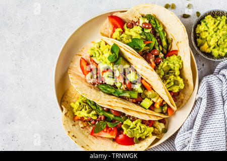 Vegan tortillas avec le quinoa, les asperges, les haricots, les légumes et le guacamole. Banque D'Images