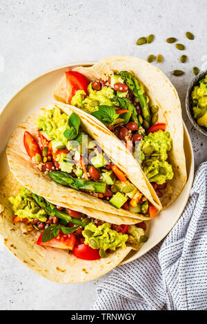 Vegan tortillas avec le quinoa, les asperges, les haricots, les légumes et le guacamole. Banque D'Images