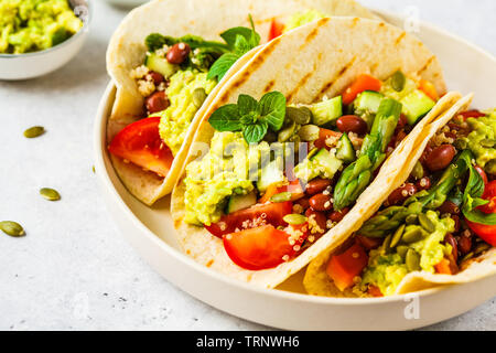 Vegan tortillas avec le quinoa, les asperges, les haricots, les légumes et le guacamole. Banque D'Images