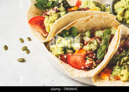 Vegan tortillas avec le quinoa, les asperges, les haricots, les légumes et le guacamole. Banque D'Images