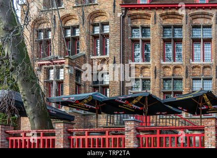 Extérieur de maison médiévale avec des vitraux, une clôture rouge et noir parasols face à l'un des canaux. Ville de Bruges rue Banque D'Images