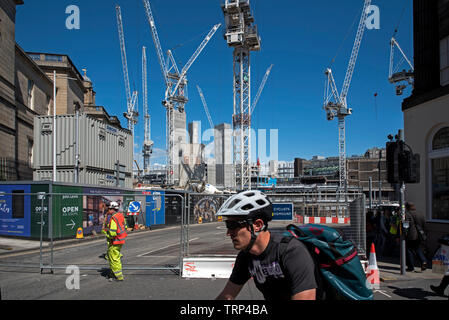 Le cycliste passe le réaménagement du centre de St James à l'extrémité est de Princes Street, Édimbourg, Écosse, Royaume-Uni. Banque D'Images