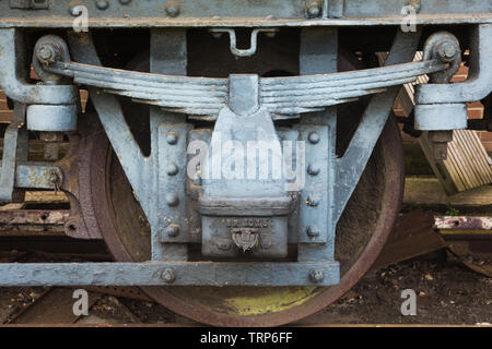 La gare ferroviaire d'ingénierie robuste en acier et système de suspension roue feuilles mécanisme peint en bleu sur les marchandises wagon à Didcot Railway Centre, Oxfordshire Banque D'Images