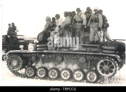 Les soldats allemands/Waffen-SS en hiver Parkas blanc ride sur un tank Panzer III lors de la bataille de Kharkov 1943 sur le front russe Banque D'Images