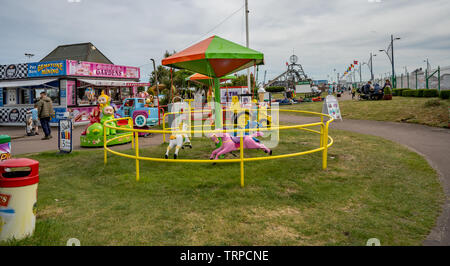 Stands de nourriture, attractions, manèges forains et de divertissement dans un des parcs le long du Golden Mile, dans la ville côtière de Great Yarmouth, Banque D'Images