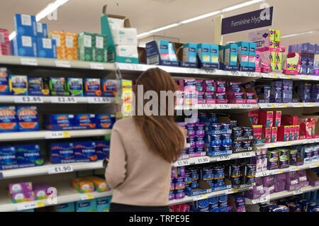 Une femme pose à la recherche de produits sanitaires dans un supermarché Tesco dans l'ouest de Londres le 9 juin 2019. Banque D'Images