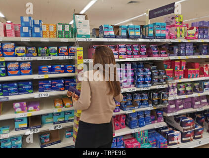 Une femme pose à la recherche de produits sanitaires dans un supermarché Tesco dans l'ouest de Londres le 9 juin 2019. Banque D'Images