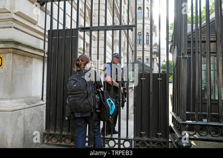 Photographe féminin attendant la permission de traverser la porte Downing Street à Westminster, dans le centre de Londres, Angleterre Royaume-Uni KATHY DEWITT Banque D'Images