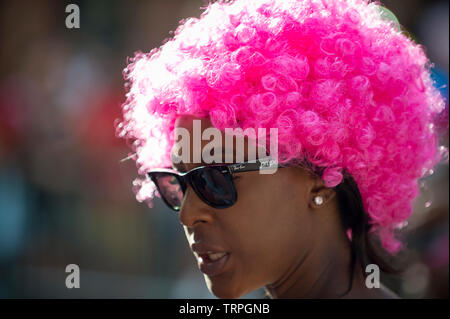 NEW YORK - 25 juin 2017 : Un spectateur porte un rose flamboyant à l'afro Pride Parade annuelle qui passe par Greenwich Village. Banque D'Images