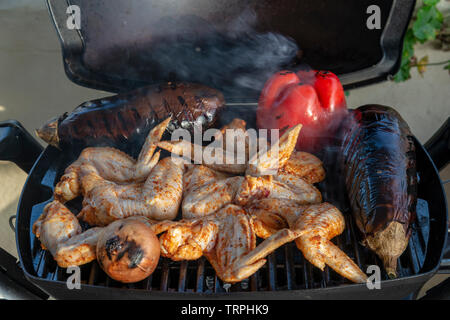 Ailes de poulet et légumes sur le grill Banque D'Images